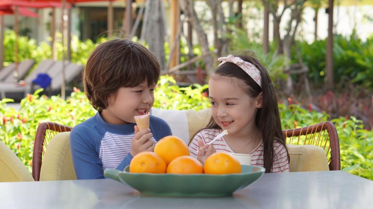 Amari Pattaya Hotel Ngoại thất bức ảnh A boy and a girl eating fruit
